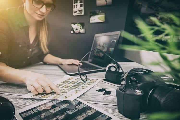 Mujer editando fotografías con cámara profesional